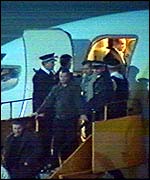 Armed police meeting fans coming off the plane