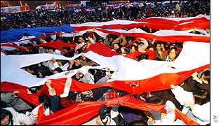 Protesters tear apart a huge US flag