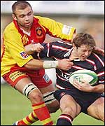 Gloucester scrum-half Andy Gomarsall is scragged by Gregory Le Corvec 