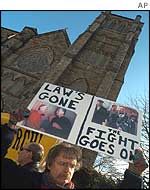 A protester holds a sign reading 'Law's gone, the fight goes on'