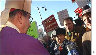 Bishop Richard Lennon faces protesters outside the church