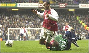 Tottenham keeper Kasey Keller brings down Thierry Henry in the penalty area