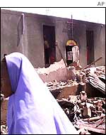 Woman walks past a destroyed church