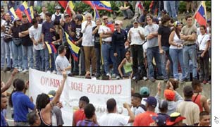 Chavez supporters (below) square off with opposition protesters in Caracas