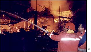 Firefighters attempt to extinguish the blaze ignited by a bomb blast at the Sari night club on Kuta Beach, on the island of Bali, Indonesia, 13 Oct 2002