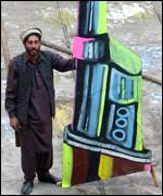 A painter holds a giant gun he produced