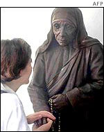 A Missionary of Charity volunteer in front of a statue of Mother Teresa in Calcutta