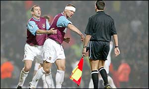 West Ham's Nigel Winterburn holds back Tomas Repka from the linesman 