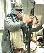 A Kashmir rebel fighter holds a rifle
