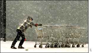 A Wal-Mart employee pushes shopping carts back toward a building in Missouri