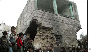 Palestinians stand in front of the two-story house of Palestinian militant leader, Hamza Abu Roub