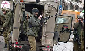 Israeli soldiers take position behind their jeeps during clashes in the West Bank town of Ramallah on Thursday