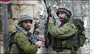 Two Israeli army soldiers look for the location of Palestinian stone-throwers during a clash in the West Bank town of Nablus