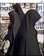 Iranian women in front of billboards