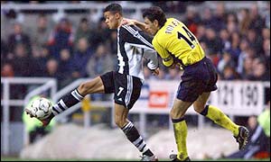 Jermaine Jenas shields the ball from Gustavo Poyet