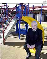 Australian Minister for Immigration Philip Ruddock sits in a children�s playground of Baxter Detention Centre near Port Augusta in South Australia, July 2002