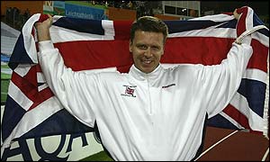 Steve Backley holds aloft the Union Jack at the Commonwealth Games
