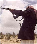 A Yemeni tribesman aims his gun