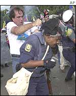 Police officer is hit by opposition supporter in Caracas