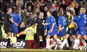 Referee Mark Halsey and his assistant are surrounded by Chelsea players as he beckons Cudicini forward