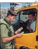 Israeli soldier stops Palestinian at checkpoint