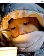 A child holds a candle during an anti-US rally near the US Embassy in Seoul 4 January 2003