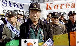 South Koreans carry pro-US placards along with US and South Korean flags during a rally outside the US air force base in Osan, south of Seoul, 8 January 2003