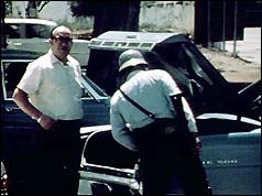 Policeman inspects car boot in Guatemala City