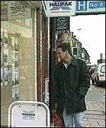 A man looking in an estate agent's window