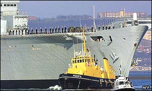 Personnel stand aboard the Ark Royal as it departs Portsmouth