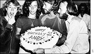 Andy Gibb eats a cherry from his birthday cake held by Maurice, in Florida 1979