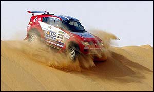 Stephane Peterhansel rides over a dune