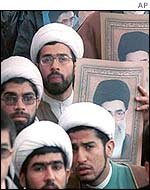 Protesters hold pictures of Ayatollah Ali Khamenei