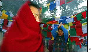 Buddhist monk wrapped in a heavy blanket tries to keep warm 