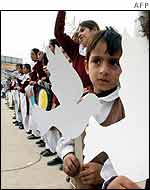 Pakistani school children carry paper doves in Rawalpindi