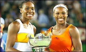 Venus and Serena Williams pose with their winners trophy