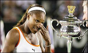 Serena Williams wipes away a tear as she is presented with the trophy