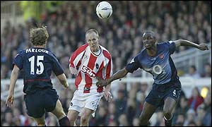 Farnborough's Danny Carroll manages to reach the ball ahead of Arsenal's Ray Parlour and Patrick Vieira