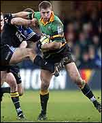 Ben Cohen holds off the tackle of England team-mate Mike Catt