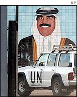 A UN weapons inspectors vehicle enters Ibn al-Haitham manufacturing facility for missile components past a mural of Iraqi leader Saddam Hussein in Baghdad