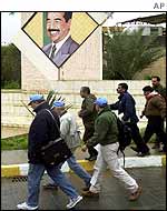 UN inspectors pass Saddam poster in Baghdad