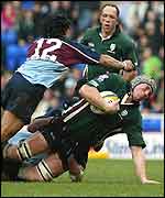 London Irish lock Bob Casey is hauled down by two Rotherham tacklers