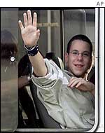 French boy waves as he rides a bus heading for the airport