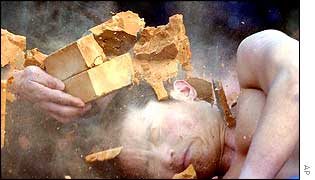 A martial arts performer has bricks broken over his head in a show of strength at the annual Temple of the Earth fair in Beijing