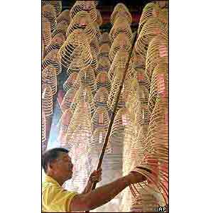 A worker prepares hundreds of traditional incense coils donated by Buddhist devotees to pray for good fortune in a Chinese temple in Kuala Lumpur