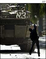 Palestinian boy throws stone at Israeli tank in Hebron