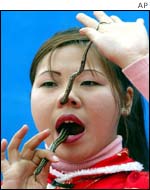 A woman threads a live snake up her nose in Beijing