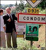 Mayor of Condom with road sign that is continually ripped off as a souvenir