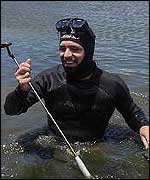 A diver retrieves Daly's putter