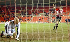 Brad Friedel looks on as Gavin McCann celebrates hitting the winning spot-kick for Sunderland